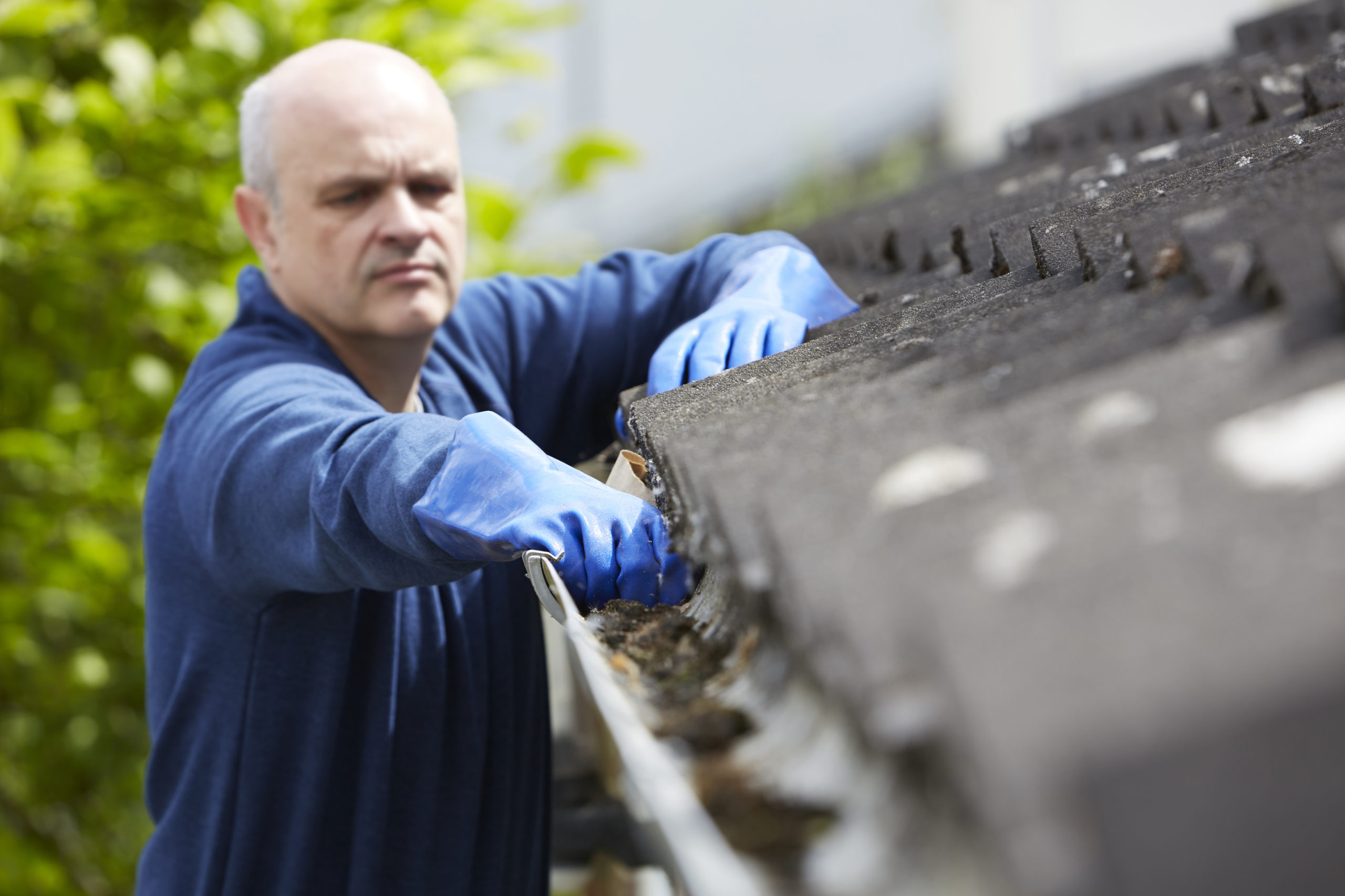 Man cleaning gutters.